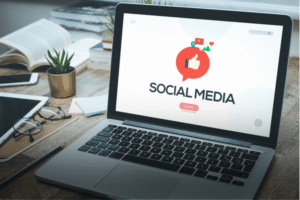 Laptop displaying a social media dashboard illustration on a desk — representing nonprofit engagement strategy and social media management